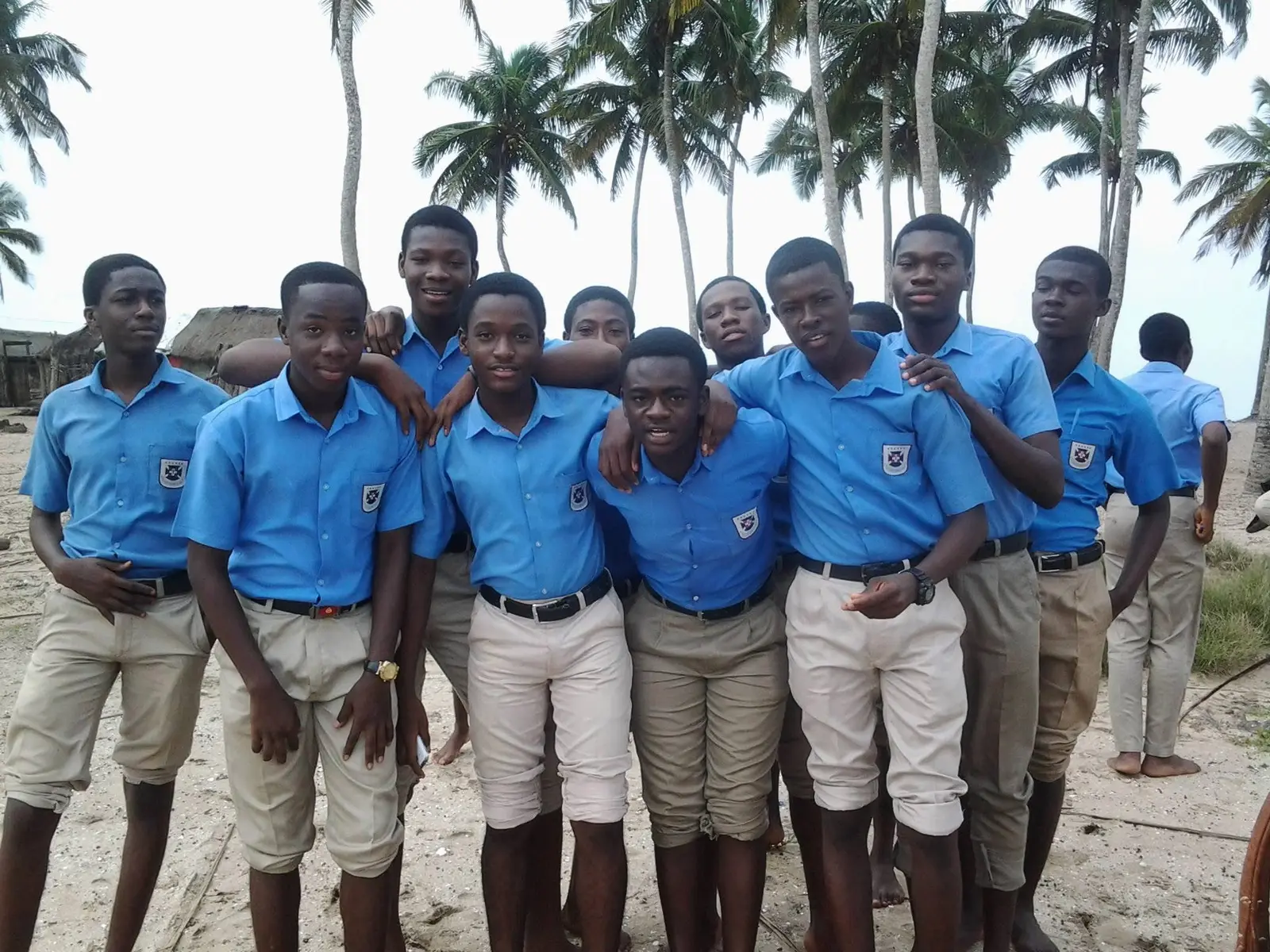 Classmates in uniform on an outing, under palm trees